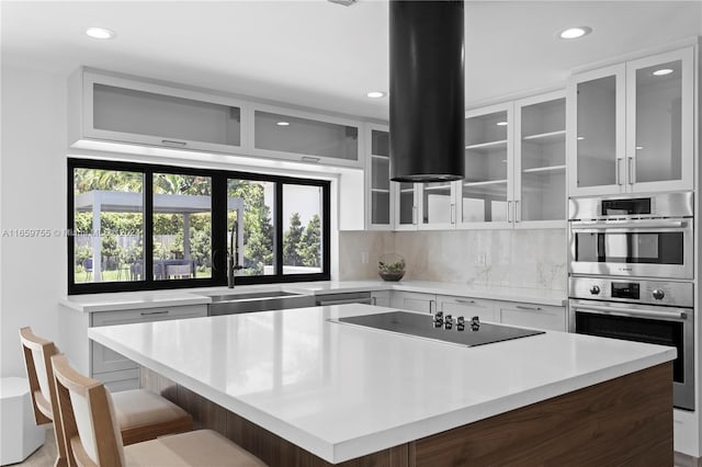 kitchen with white cabinets, plenty of natural light, a kitchen island, and a breakfast bar