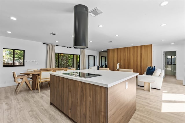 kitchen with a large island with sink, modern cabinets, visible vents, recessed lighting, and black electric stovetop