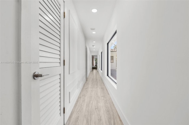 corridor featuring recessed lighting, light wood-style floors, and baseboards