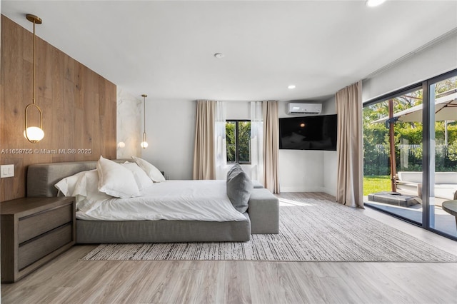 bedroom featuring a wall mounted AC, recessed lighting, wood walls, access to exterior, and wood finished floors