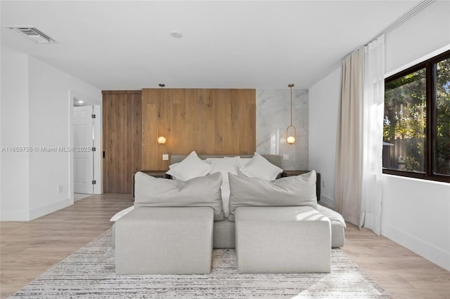 bedroom featuring light wood-style flooring, baseboards, and visible vents