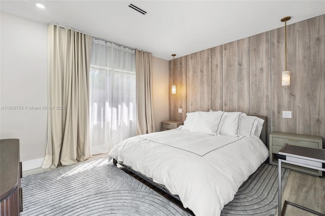 bedroom featuring visible vents and wood walls