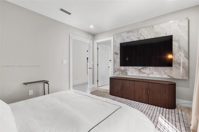 bedroom featuring visible vents, baseboards, recessed lighting, and wood finished floors