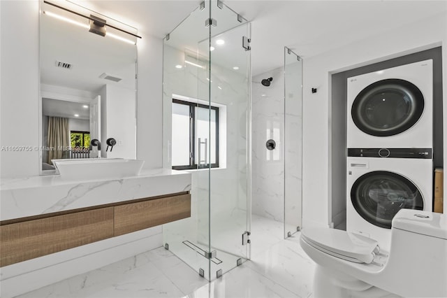 bathroom with toilet, a marble finish shower, visible vents, stacked washer / drying machine, and marble finish floor