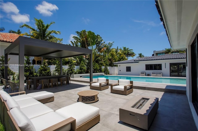 view of swimming pool with an outdoor living space with a fire pit and a patio