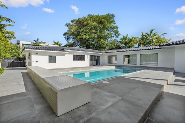pool with a patio area and fence