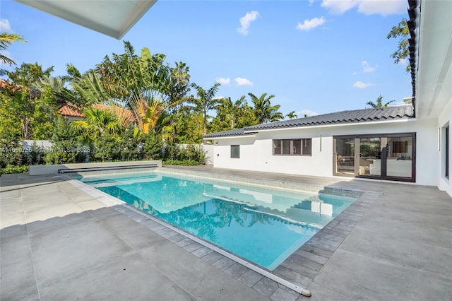 pool with a patio area and fence