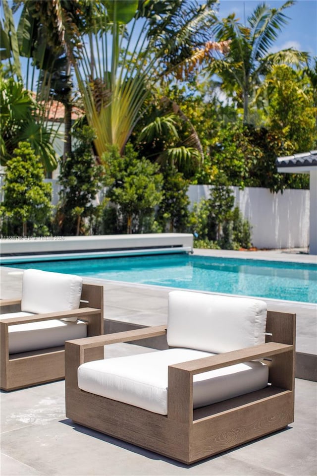 view of pool featuring a patio area, an outdoor living space, fence, and a fenced in pool