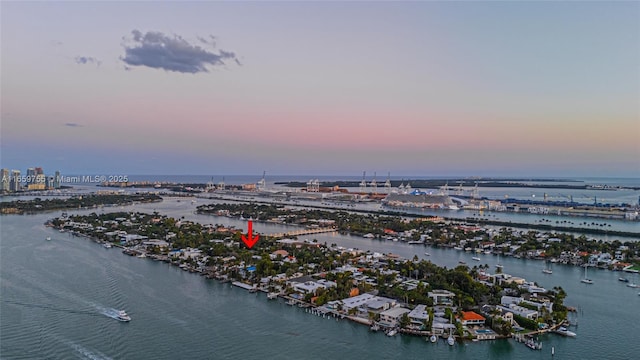 aerial view at dusk featuring a water view