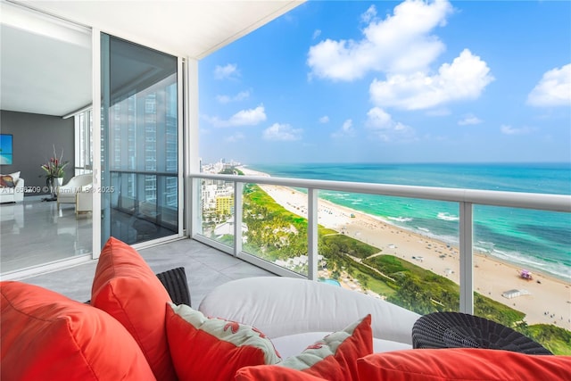 balcony featuring an outdoor living space, a view of the beach, and a water view