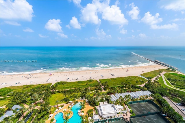 birds eye view of property with a water view and a beach view