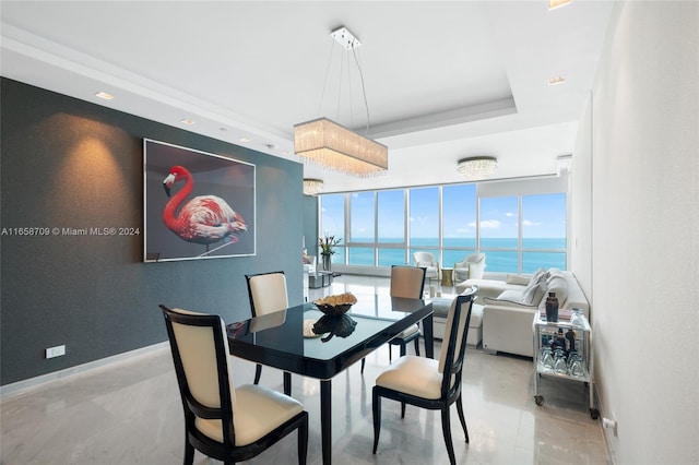 living room featuring a tray ceiling and a notable chandelier