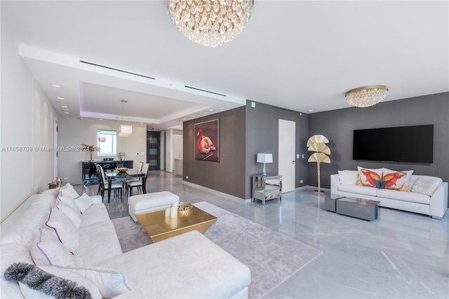 living room featuring a raised ceiling and an inviting chandelier