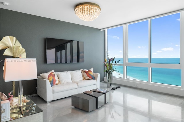 living room with a notable chandelier, finished concrete flooring, and a water view