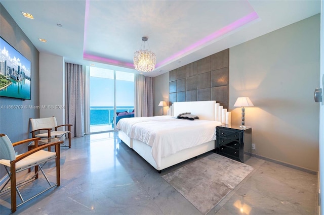 bedroom featuring a water view, a tray ceiling, a wall of windows, and access to outside