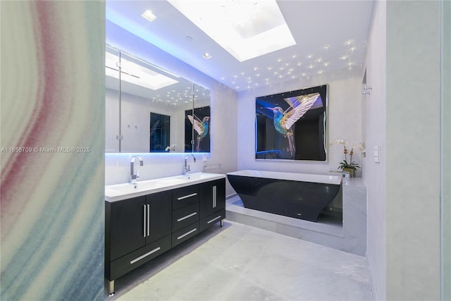 full bathroom featuring double vanity, a freestanding bath, a skylight, and a sink