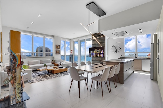 tiled dining room with a water view, sink, and plenty of natural light