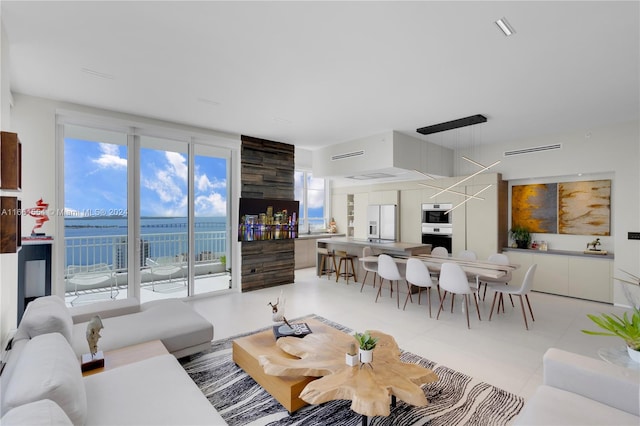 living room featuring a water view and light tile patterned floors