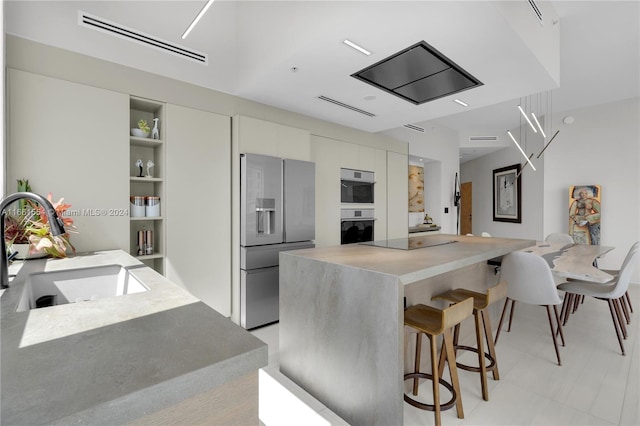 kitchen with stainless steel appliances, a kitchen island, and sink