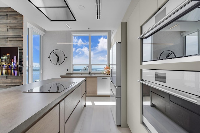 kitchen featuring light tile patterned floors, stainless steel appliances, and sink