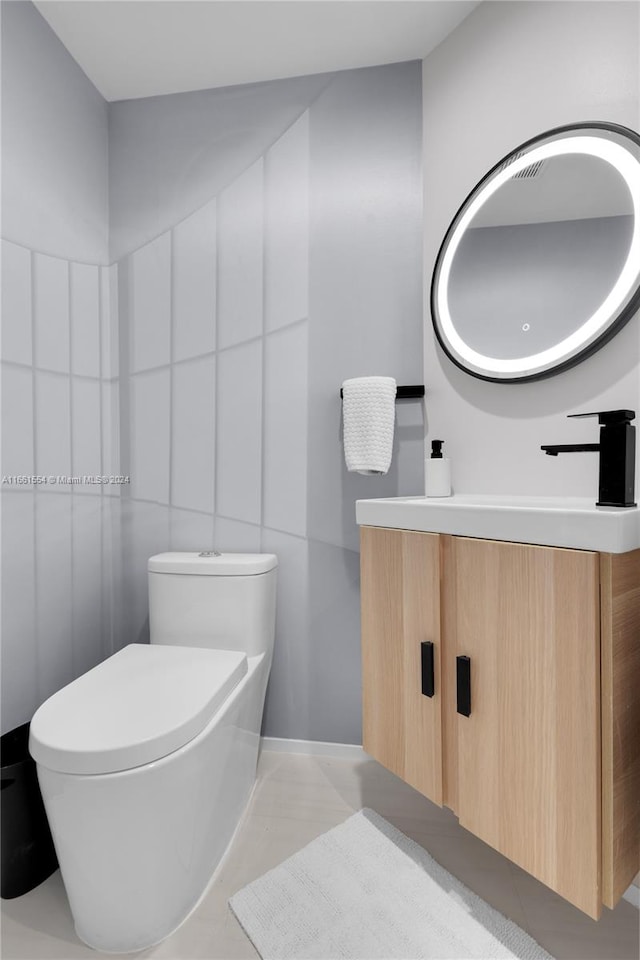 bathroom featuring vanity, tile walls, tile patterned flooring, and toilet