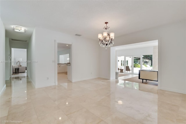 unfurnished room with an inviting chandelier