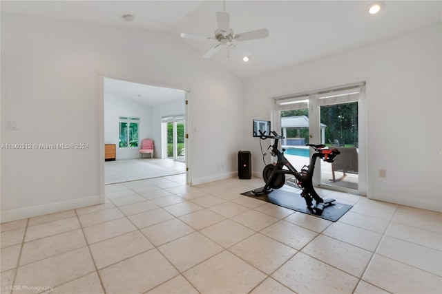 exercise area with light tile patterned floors, vaulted ceiling, ceiling fan, and plenty of natural light