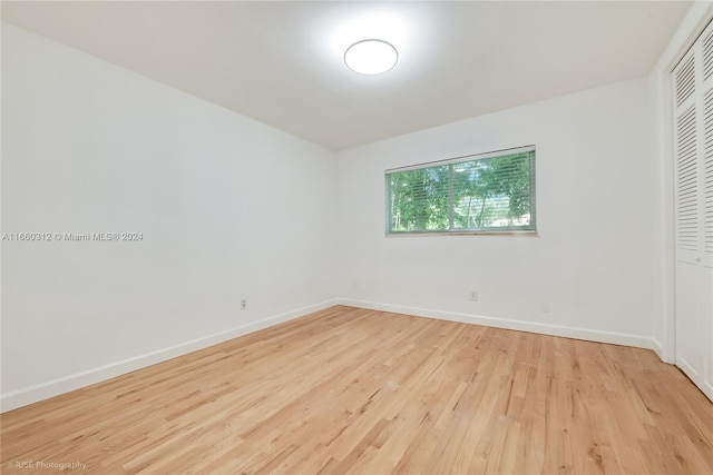 unfurnished bedroom with light hardwood / wood-style flooring and a closet