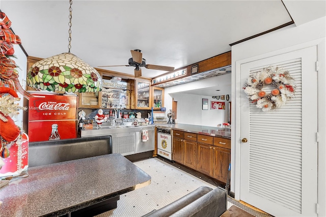 kitchen with ceiling fan, stainless steel counters, and decorative light fixtures