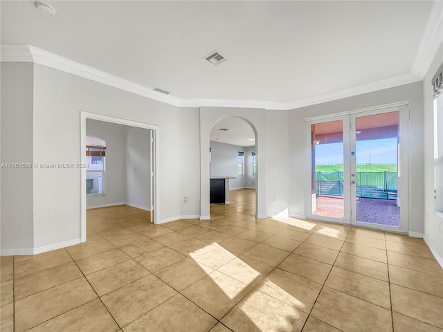 tiled empty room featuring crown molding and french doors