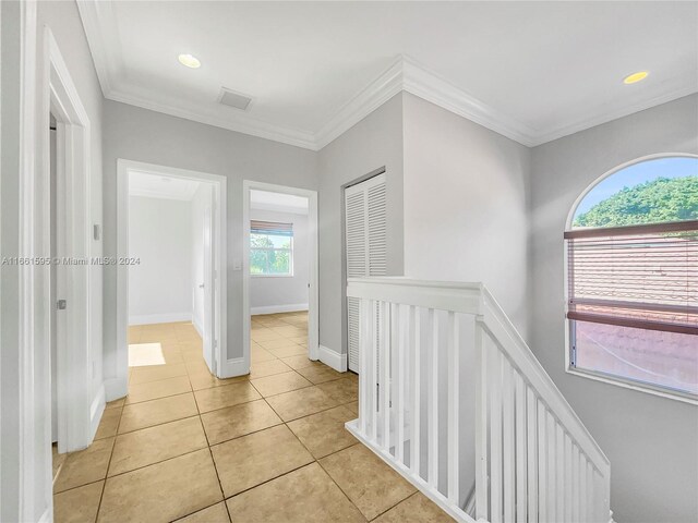 hall with crown molding, light tile patterned floors, and a wealth of natural light