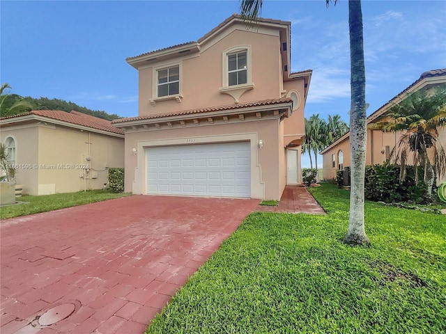 mediterranean / spanish-style house featuring a garage and a front lawn