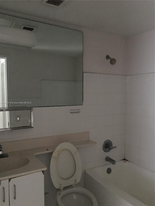 full bathroom with tiled shower / bath combo, vanity, and toilet