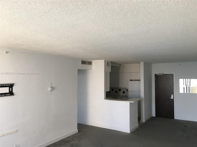 kitchen with a textured ceiling and white fridge