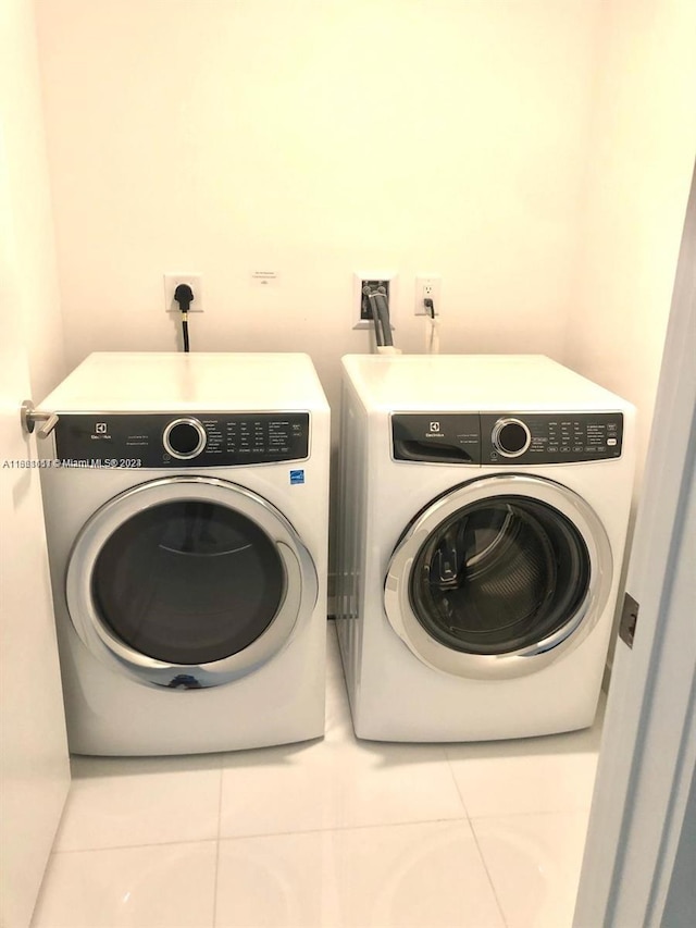 laundry room with washer and dryer and tile patterned floors