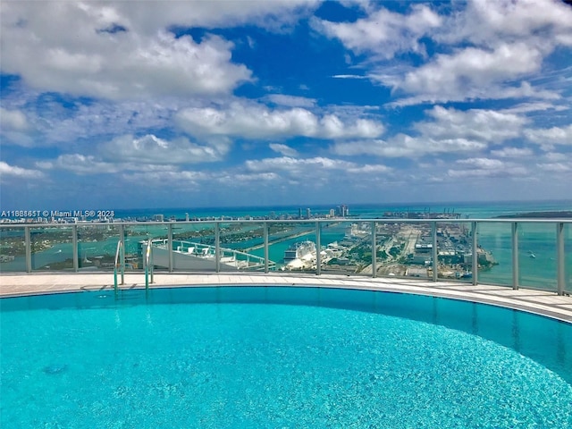 view of swimming pool featuring a water view