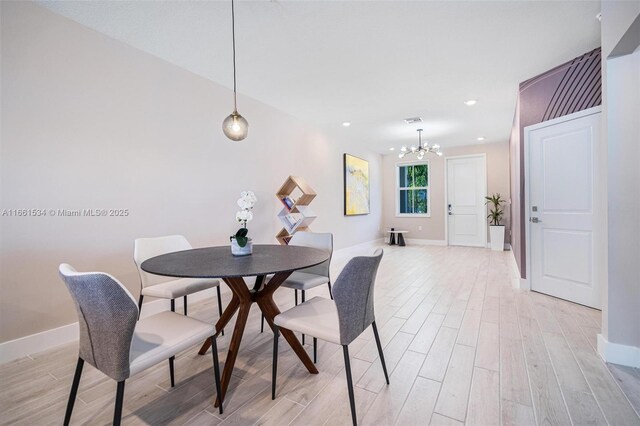 dining space with a chandelier and light hardwood / wood-style floors