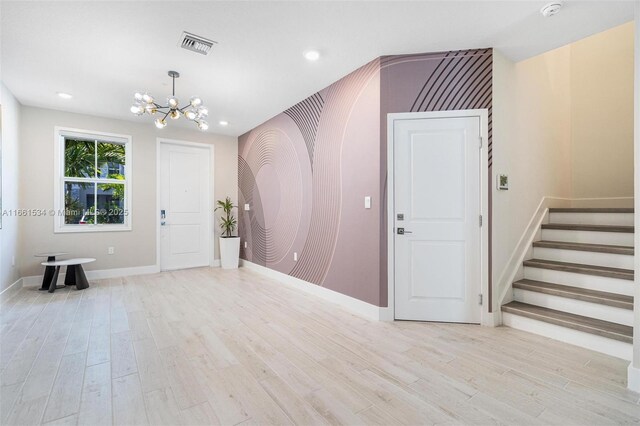 entrance foyer featuring light hardwood / wood-style flooring and a notable chandelier