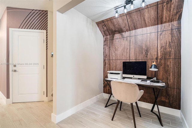 office featuring rail lighting, wood finished floors, and baseboards