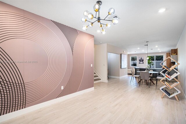 dining area with light hardwood / wood-style floors and an inviting chandelier