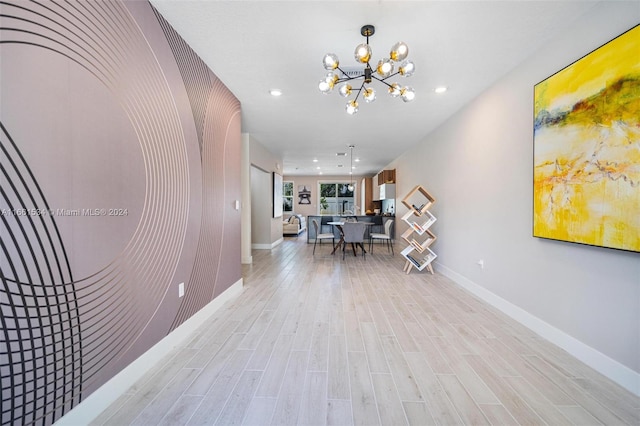 hall featuring an inviting chandelier and light wood-type flooring