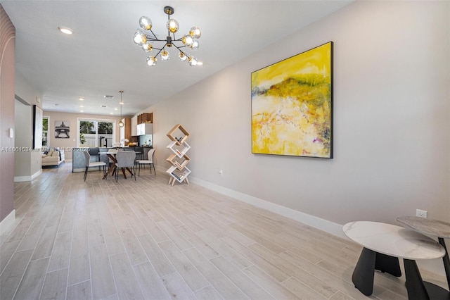 interior space with light wood finished floors, a notable chandelier, recessed lighting, and baseboards