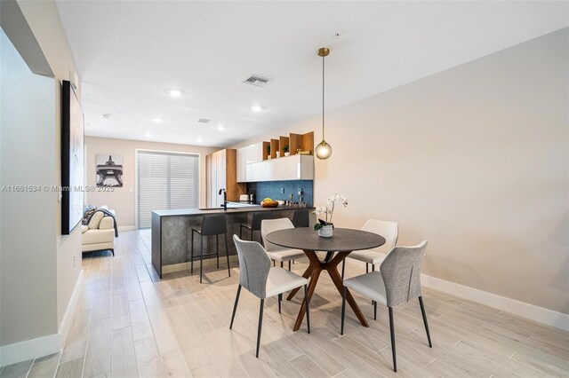 dining space with light hardwood / wood-style flooring and sink