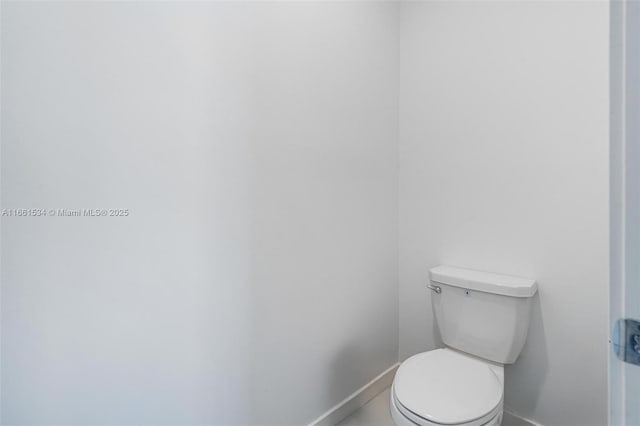 bathroom with toilet and baseboards