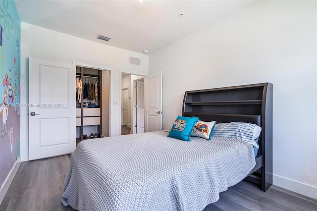 bedroom with dark wood-type flooring and a closet