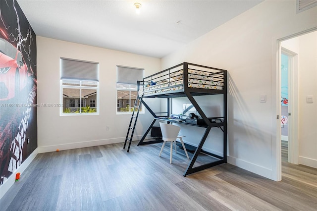 unfurnished bedroom with visible vents, baseboards, and wood finished floors