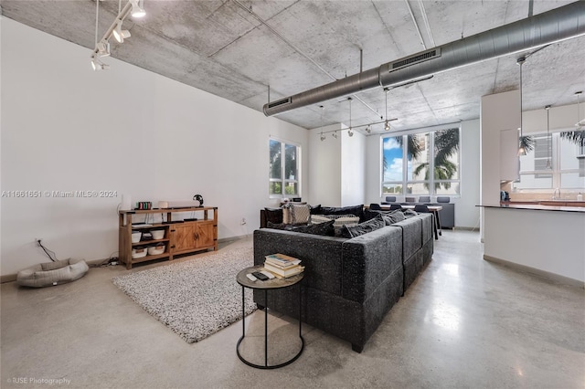 living room featuring concrete flooring and rail lighting