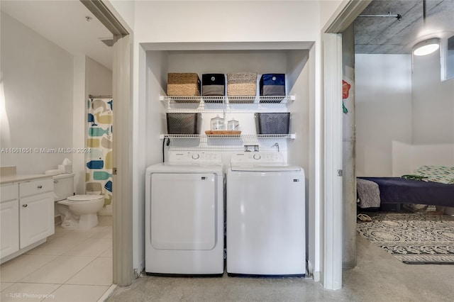 clothes washing area with independent washer and dryer and light tile patterned floors