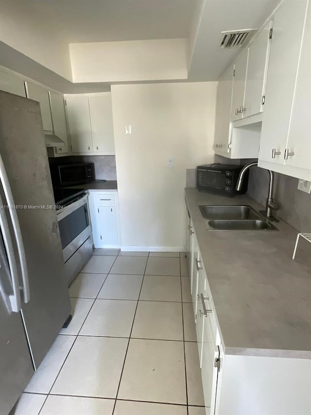 kitchen with white cabinetry, appliances with stainless steel finishes, sink, and light tile patterned floors