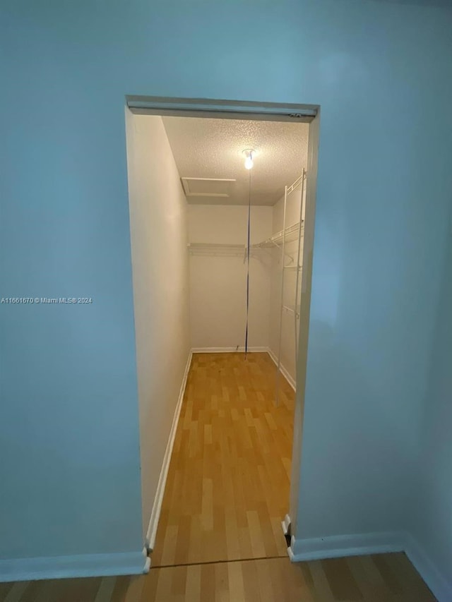 hallway featuring wood-type flooring and a textured ceiling